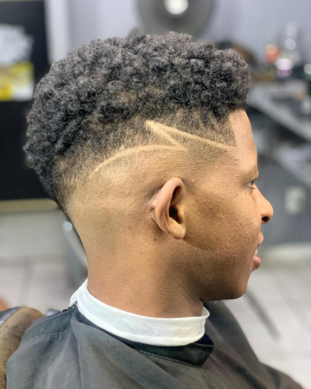Corte com degradê alto e desenho freestyle na navalha