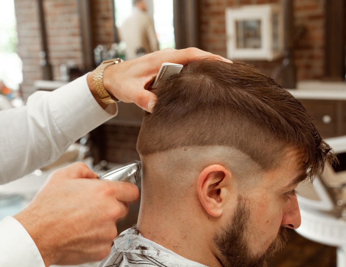 Barbeiro fazendo degradê em um cliente